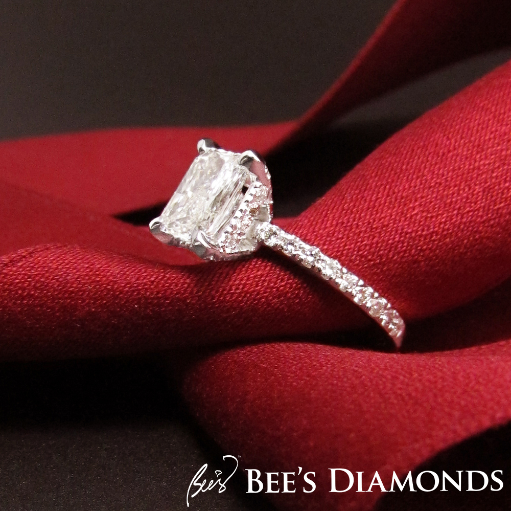 Emerald cut diamond engagement ring with thin band of diamonds